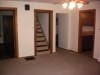 living room - door to bedroom, stairway up, hallway, and kitchen